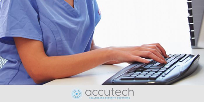 Health care worker typing on a computer keyboard